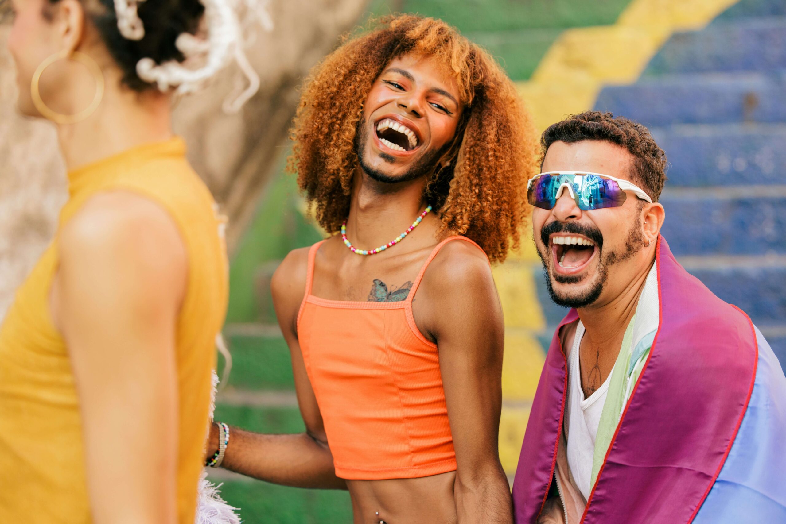 Smiling person in an orange top, symbolizing joy and positive outcomes from MitoKhon's community outreach program design and health impact measurement initiatives.