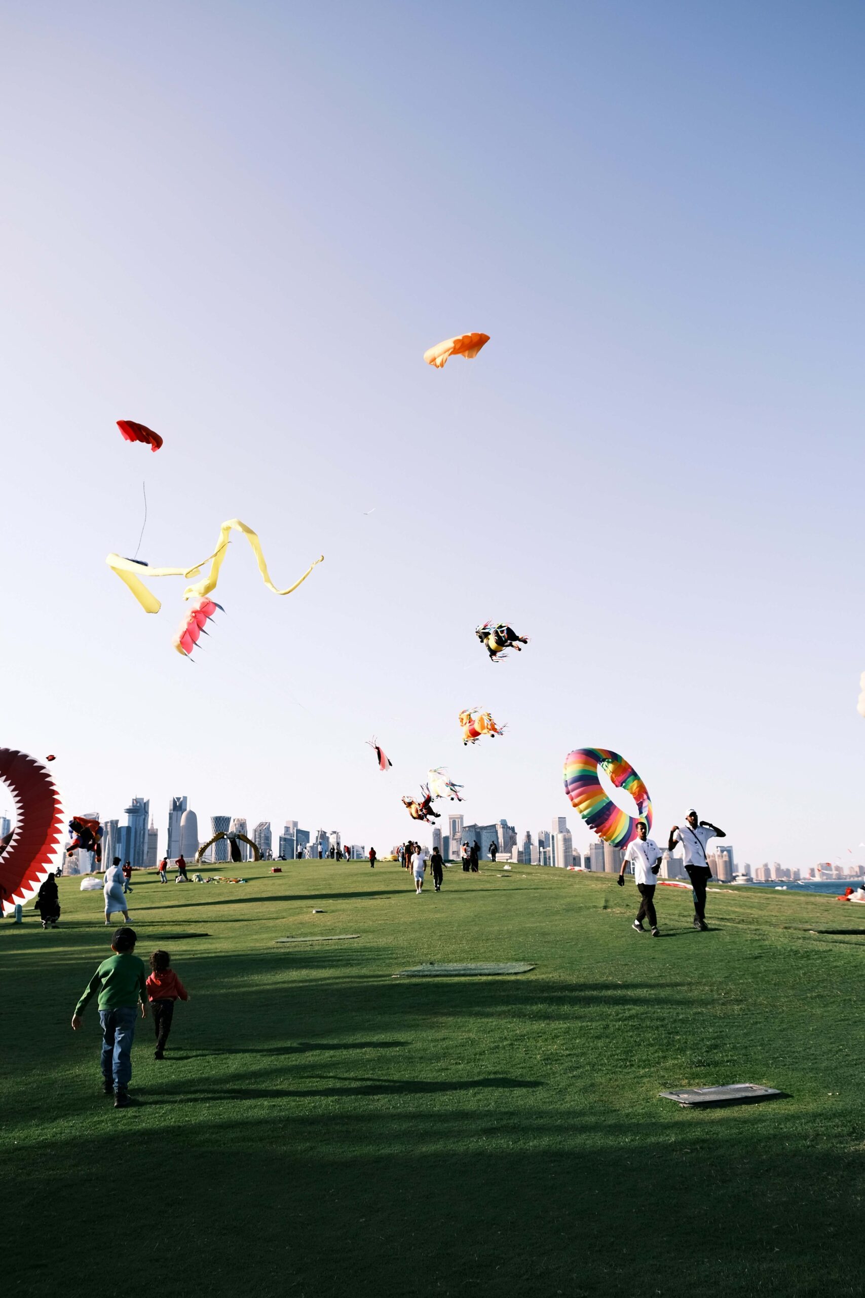 People flying kites in a park with a city skyline in the background, symbolizing MitoKhon's commitment to care and community.